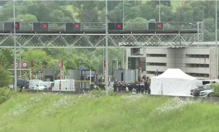 Police and other officials are seen near a toll booth on a highway in Val-de-Reuil, northern France, May 14, 2024, where heavily armed assailants attacked a prison van carrying a convicted burglar, allowing him to escape. / Credit: REUTERS/BFM-TV