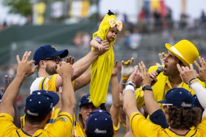 Savannah Bananas team owner Jesse Cole, right, oversees the presentation of the &quot;Banana baby.&quot;