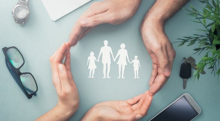 Family care concept photo (two pairs of hands circling the drawing of a family)