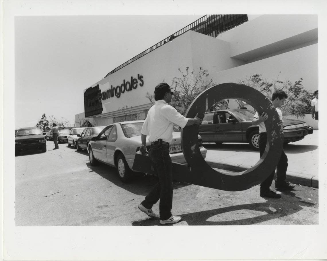 File photo shows work crews carrying a letter to help repair the former Bloomingdale’s sign at The Falls outdoor shopping mall after Hurricane Andrew damaged the South Miami-Dade attraction and surrounding neighborhoods in August 1992. In August 2023, a Life Time Fitness resort-style gym center replaced the Bloomingdale’s, which had been closed since March 2020.