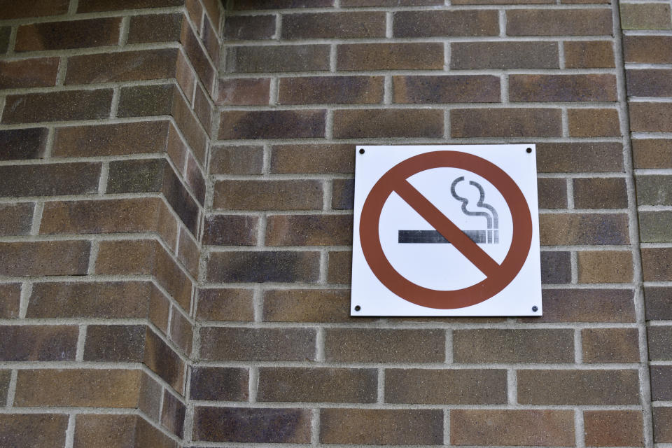 A "No Smoking" sign against a brick wall