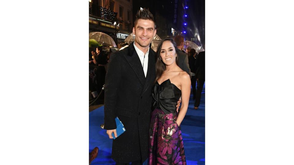 Aljaz Skorjanec in suit standing with Janette Manrara in a floral skirt