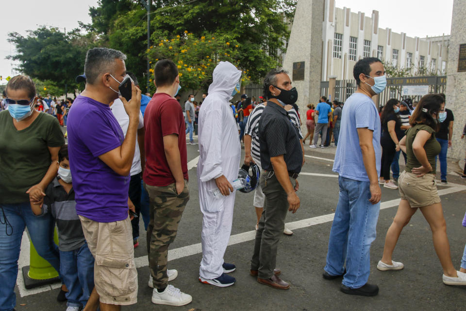 Voters line up outside the Vicente Rocafuerte school during general elections in Guayaquil, Ecuador, Sunday, Feb. 7, 2021. Ecuadoreans went to the polls in first-round presidential legislative elections. (AP Photo/Angel Dejesus)