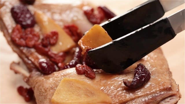 Placing ginger, wolfberries and red dates onto duck