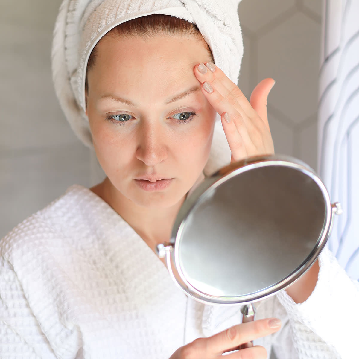 woman-looking-at-skin-hand-mirror