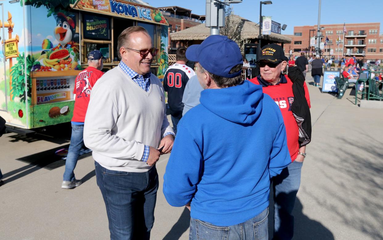 Andrew Berlin, left, chairman and owner of the South Bend Cubs, walks the concourse talking to fans Tuesday, April 9, 2024, at the South Bend Cubs home baseball opener against the Wisconsin Timber Rattlers at Four Winds Field in South Bend.