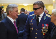 In this photo taken on Thursday, Feb. 14, 2019, Vladimir Vshivtsev, a veteran of the Soviet war in Afghanistan, right, and Gen. Col. Boris Gromov, former Commander of the 40th Army in Afghanistan, greet each other during a meeting at the upper chamber of Russian parliament in Moscow, Russia. Vshivtsev, who was wounded in action and lost his eye-sight, became a leading activist in the Russian Society for the Blind and served a stint in the Russian parliament. (AP Photo/Alexander Zemlianichenko)