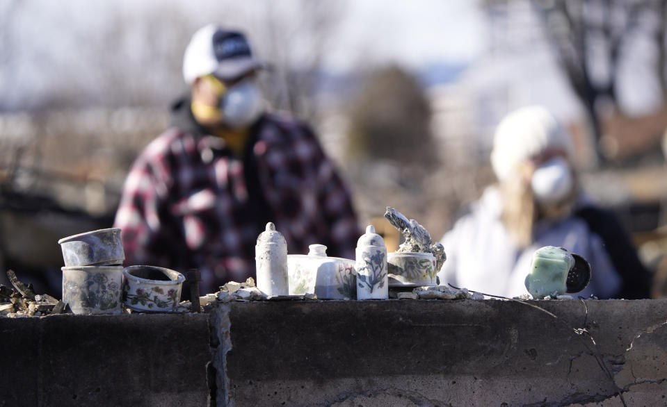 Recovered items are lined up on the foundation as members of the Stephens family sift through the remains of their home destroyed by wildfires Tuesday, Jan. 4, 2022, in Superior, Colo. (AP Photo/David Zalubowski)