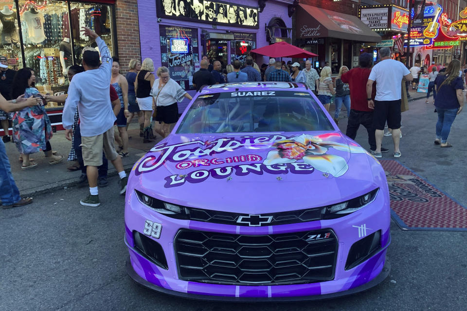 The No. 99 Chevrolet driven by Daniel Suarez for Trackhouse Racing is displayed outside Tootsie’s Orchid Lounge in Nashville, Tenn., Thursday, June 17, 2021. Trackhouse hopes to be operating from downtown Nashville by 2023 and Marks is using Sunday’s first Cup race in the market in 37 years to lay the groundwork for his move. (AP Photo/Jenna Fryer)