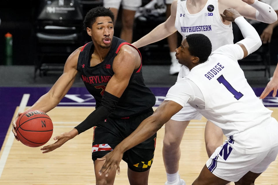 Maryland guard Aaron Wiggins, left, looks to pass as Northwestern guard Chase Audige guards during the first half of an NCAA college basketball game in Evanston, Ill., Wednesday, March 3, 2021. (AP Photo/Nam Y. Huh)