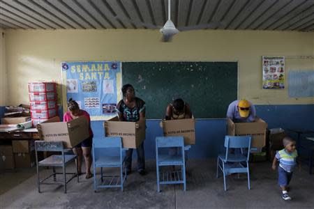 Residents prepare their ballots in voting booths during the presidential election at a polling station in Panama City May 4, 2014. REUTERS/ Carlos Jasso