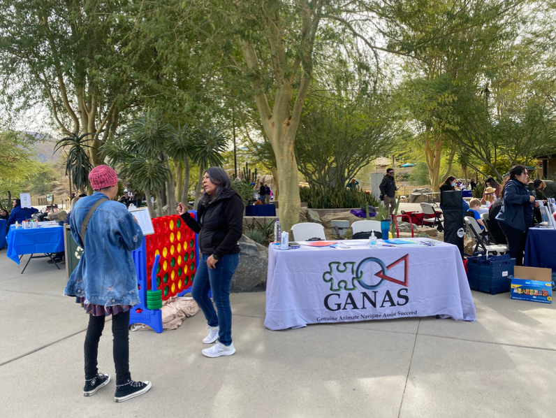 Maria Martinez, right, speaks with a community member about GANAS, a nonprofit that seeks to empower parents who have children with disabilities.