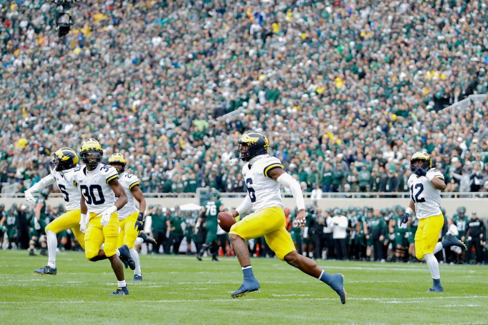 Michigan Wolverines defensive back R.J. Moten (6) runs back to the sideline in celebration after making an interception during the first quarter against the Michigan State Spartans at Spartan Stadium, Oct. 30, 2021 in East Lansing.