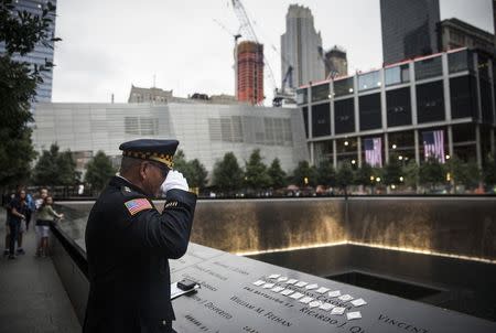 Sam Pulia, mayor of Westerchester, IL, and a former police officer of the same town, salutes the name of his cousin, New York firefighter Thomas Anthony Casoria, who was killed in the South Tower, prior to the the memorial observances held at the site of the World Trade Center in New York, September 11, 2014. REUTERS/Andrew Burton/Pool