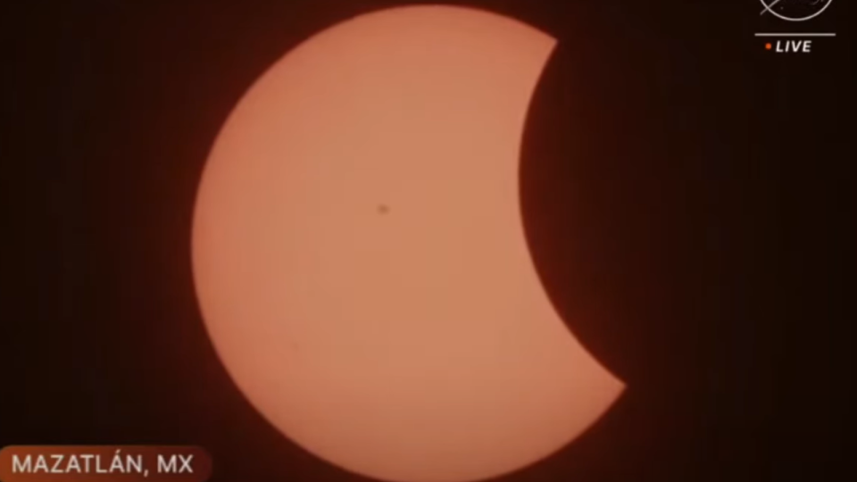 The moon begins to move in front of the sun in Mazatlan, Mexico