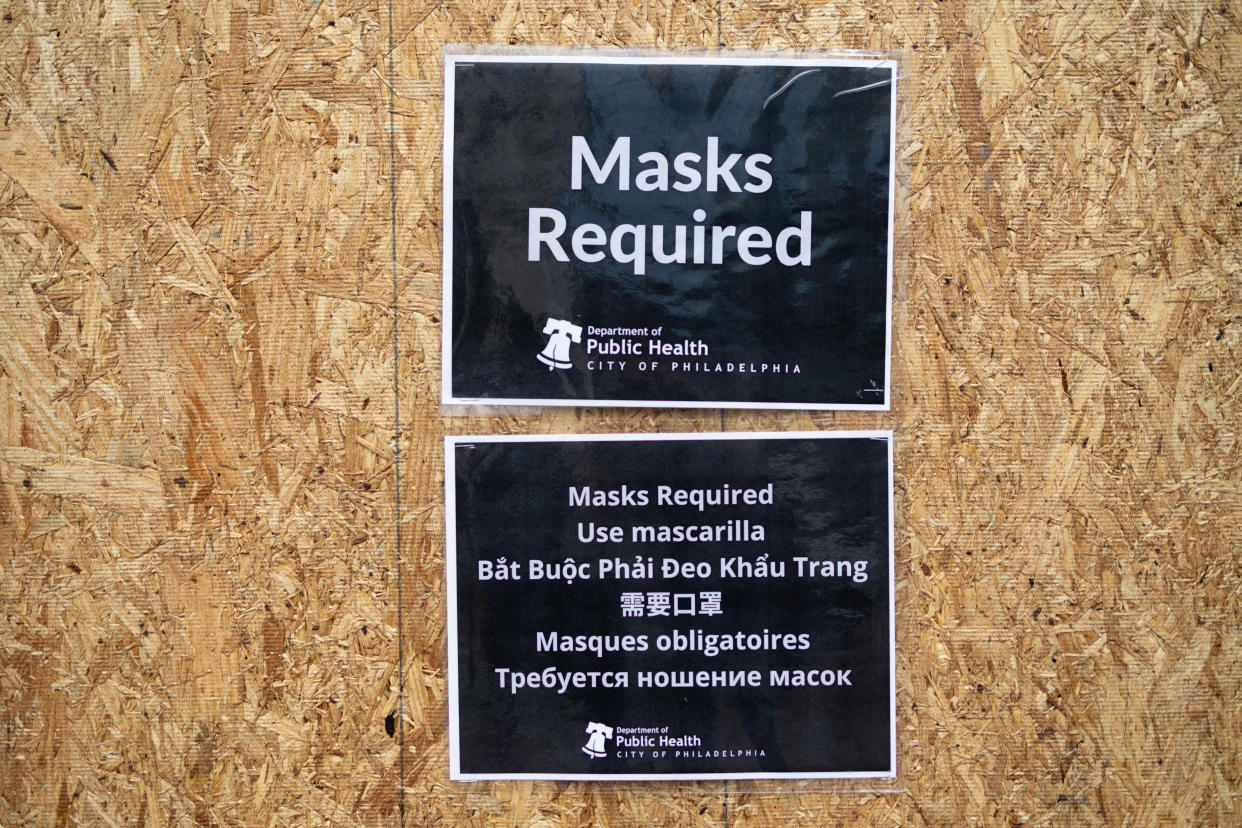 A sign outside of a restaurant reads: Masks Required.