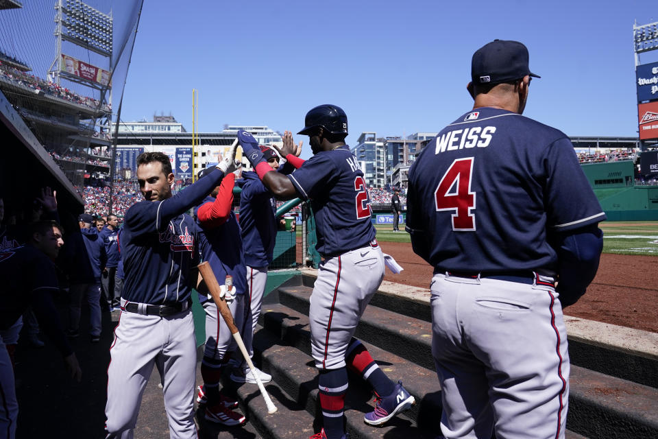 Atlanta Braves' Michael Harris II, center, high-fives teammates in the dugout after scoring on Orlando Arcia's single during the second inning of an opening day baseball game against the Washington Nationals at Nationals Park, Thursday, March 30, 2023, in Washington. (AP Photo/Alex Brandon)