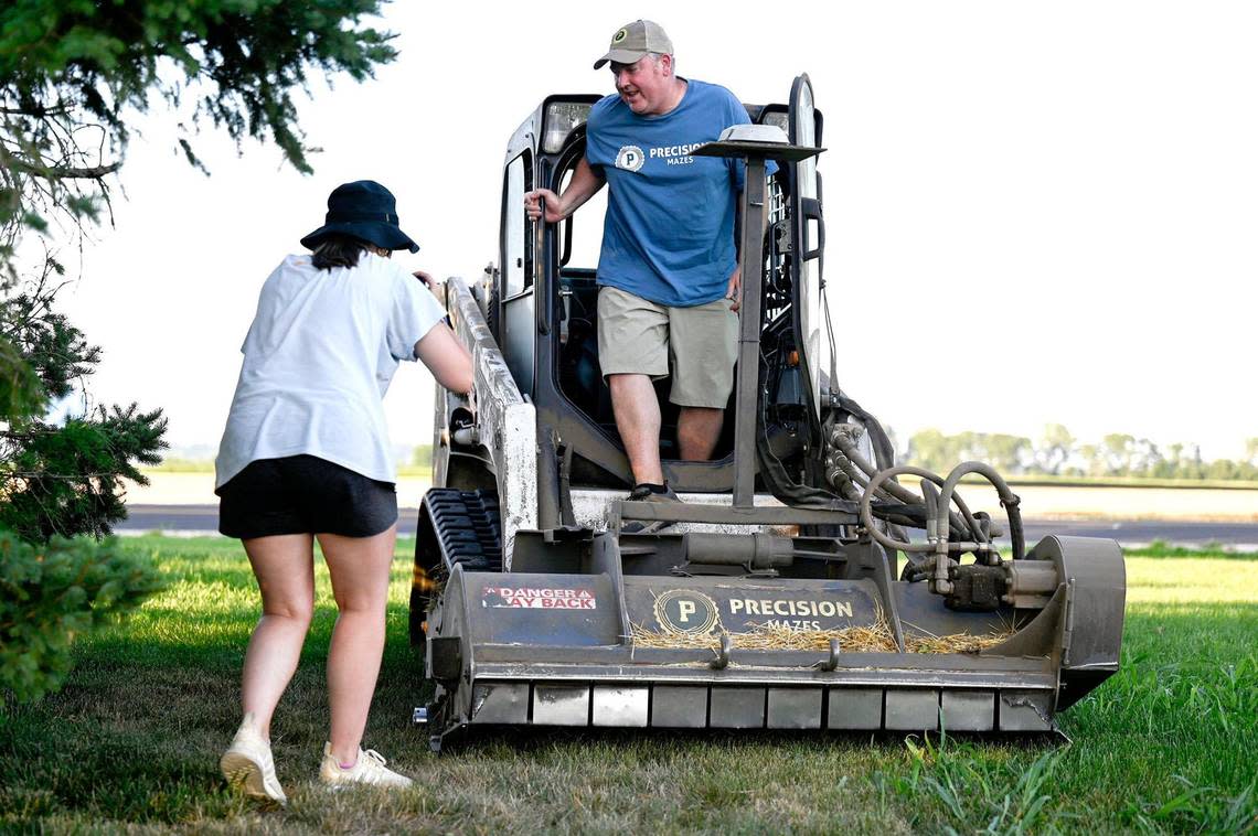 Rob Stouffer of Precision Mazes, climbs out of his bobcat as his daughter, Madeline McConnell tapes him for a social media post on Monday, July 3, 2023, in Orrick, Missouri. Stouffer spent about 13 hours cutting a welcome message to Taylor Swift in a field of wheat stubble in Orrick, Missouri, in Ray County.