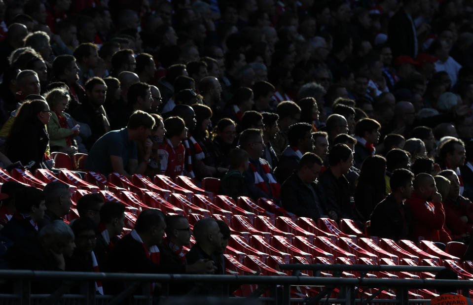 Supporters gather around 96 empty seats covered with Liverpool scarves in memory of the victims of the Hillsborough disaster, as they watch the English FA Cup semifinal soccer match between Wigan Athletic and Arsenal at Wembley Stadium in London, Saturday, April 12, 2014. 96 soccer supporters died and many more injured at the Hillsborough Stadium in Sheffield on April 15, 1989, during the FA Cup semifinal soccer match between Liverpool and Nottingham Forest. (AP Photo/Sang Tan)