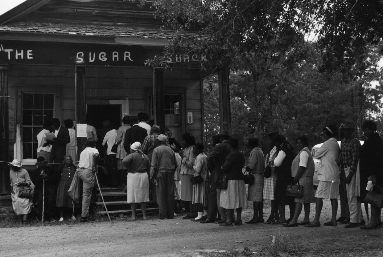 A group of voters lining up outside the polling station, a small Sugar Shack store, on May 3, 1966, in Peachtree, Ala., after the Voting Rights Act was passed the previous year. <a href="https://www.gettyimages.com/detail/news-photo/group-of-voters-lining-up-outside-the-polling-station-a-news-photo/3088626?phrase=Voting%20Rights%20Act&adppopup=true" rel="nofollow noopener" target="_blank" data-ylk="slk:MPI/Getty Images;elm:context_link;itc:0;sec:content-canvas" class="link ">MPI/Getty Images</a>