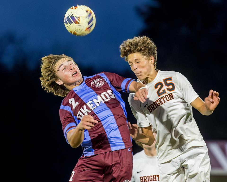 Brighton's Mitch Tappen (25) battles Okemos' Abe Fischer (2) for the ball during the Bulldogs' 1-0 district soccer victory Thursday, Oct. 12, 2023.