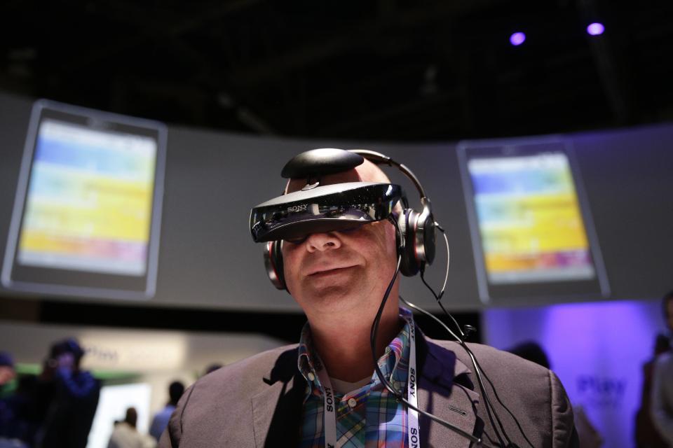 Juergen Boyny, of Germany, watches a video clip with a personal viewing device at the Sony booth at the International Consumer Electronics Show(CES) on Thursday, Jan. 9, 2014, in Las Vegas. (AP Photo/Jae C. Hong)