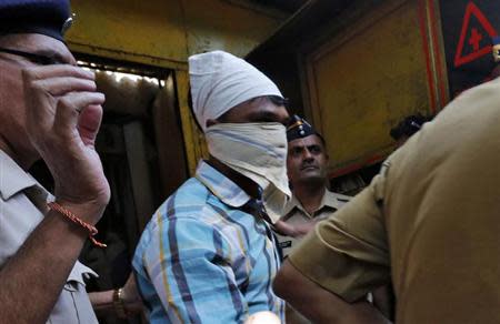 Police escort one of the four men convicted of raping a photojournalist outside a jail in Mumbai March 21, 2014. REUTERS/Mansi Thapliyal/Files