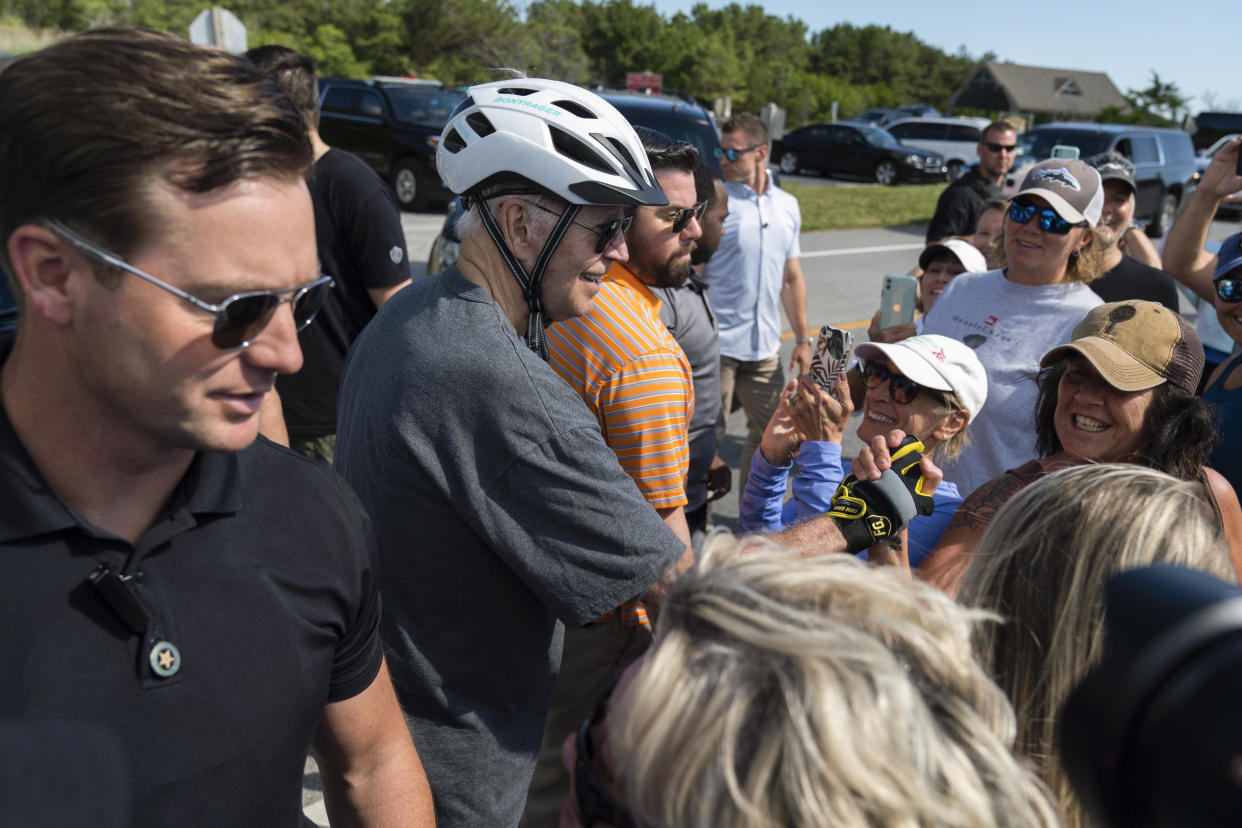 President Joe Biden, surrounded by U.S. Secret Service agents, talks to a crowd after falling from his bike on a trail at Gordons Pond in Rehoboth Beach, Del., Saturday, June 18, 2022. Biden is spending the weekend at his Rehoboth Beach home. (AP Photo/Manuel Balce Ceneta)