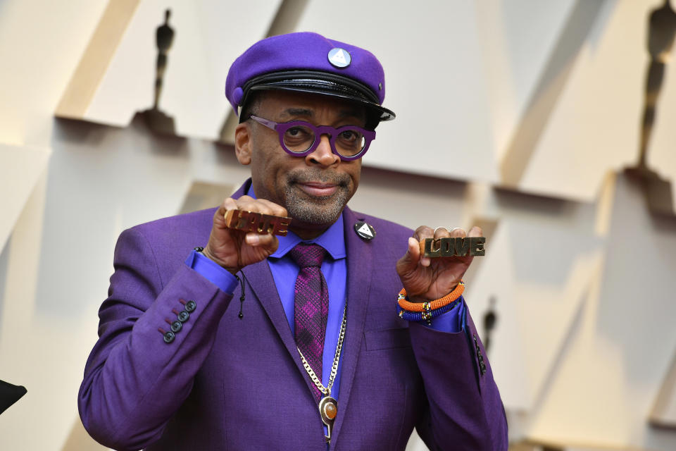 Spike Lee holds up brass knuckles reading “hate” and “love” from his iconic film <em>Do the Right Thing</em> as he arrives at the Oscars. (Photo by Jordan Strauss/Invision/AP)