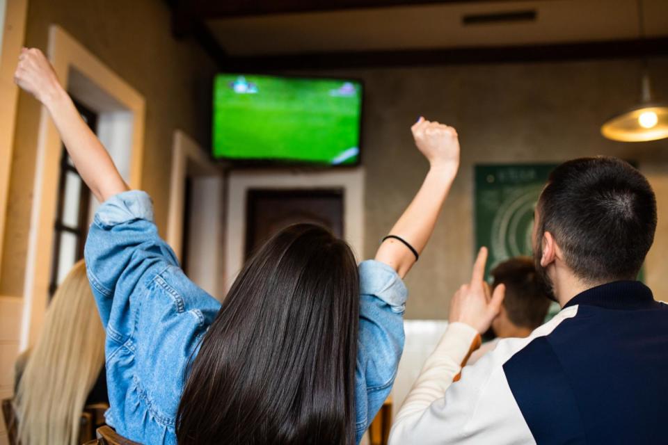 PHOTO: A group of friends watching a football game on TV at a bar. (STOCK PHOTO/Getty Images)