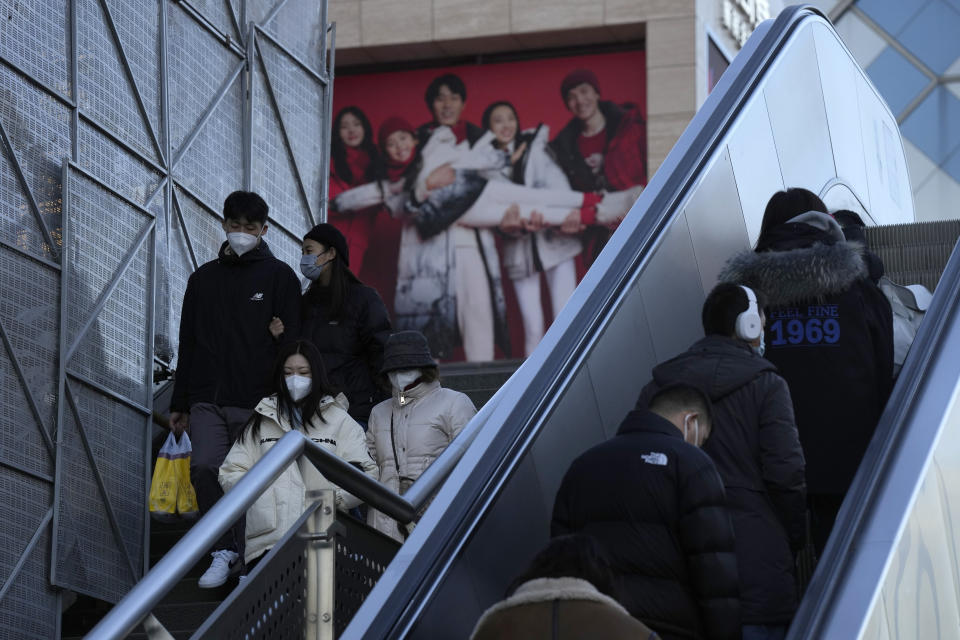 Shoppers return to the Xidan shopping district in Beijing, Thursday, Dec. 29, 2022. China is on a bumpy road back to normal life as schools, shopping malls and restaurants fill up again following the abrupt end of some of the world's most severe restrictions even as hospitals are swamped with feverish, wheezing COVID-19 patients. (AP Photo/Ng Han Guan)