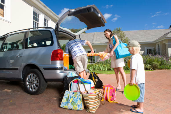 B0BMDA Family of four outside house, smiling, portrait vacation packing minivan beach attire alamy