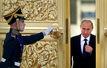 An honor guard opens the door as Russian President Vladimir Putin (R) enters a hall to attend a meeting with members of the Presidential Council for Civil Society and Human Rights at the Kremlin in Moscow, Russia, October 1, 2015. REUTERS/Yuri Kochetkov/Pool/File Photo