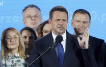 FILE - In this June 28, 2020, file photo, a candidate in Poland's presidential election, Warsaw Mayor Rafal Trzaskowski, front, reacts to the exit poll after voting closed, in Warsaw, Poland. Trzaskowski and President Andrzej Duda are heading into a tight presidential runoff that is seen as an important test for populism in Europe. The Sunday, July 12 election comes after a bitter campaign that has exacerbated a conservative-liberal divide in the country. (AP Photo/Czarek Sokolowski, File)