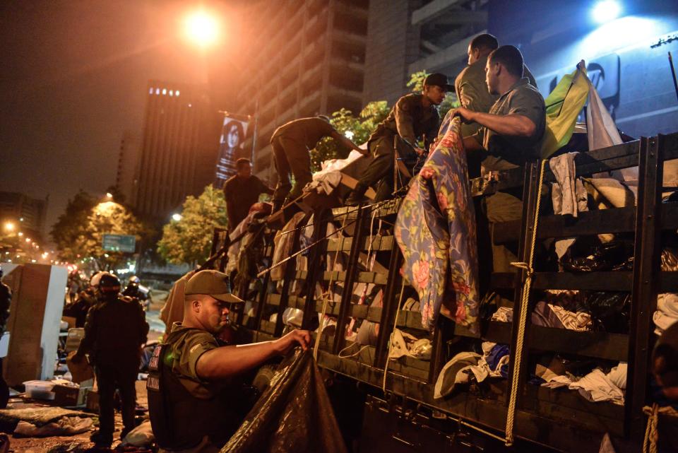 Bolivarian National Guard soldiers load a truck with students belongings as they dismantle student encampments outside of UN headquarters in Caracas, Venezuela, Thursday, May 8, 2014. Hundreds of security forces broke up four camps maintained by student protesters, arresting more than 200 people in a pre-dawn raid. The camps of small tents were installed more than a month ago in front of the UN building and other anti-government strongholds in the capital to protest against President Nicolas Maduro's government. (AP Photo/Carlos Becerra)