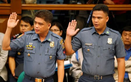 Policemen accused by a woman of killing a couple who she says are her parents, alleged by police as drug pushers during an illegal drugs "meth" raid, take their oath before they testify at a Senate hearing in Pasay, Metro Manila, Philippines August 23, 2016. REUTERS/Erik De Castro