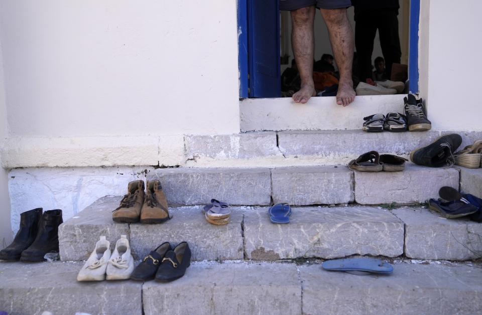 An injured Afghan stands on the stairs of an old school used as a temporary shelter on the island of Kythira, southern Greece, Friday, Oct. 7, 2022. Strong winds were hampering rescue efforts at two Greek islands Friday for at least 10 migrants believed to be missing after shipwrecks left more than 20 people dead, officials said. (AP Photo/Thanassis Stavrakis)