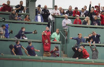 Baseball fans attempt to catch a home run ball hit by Boston Red Sox Kyle Schwarber against the Tampa Bay Rays during the first inning during game 3 of a baseball American League Division Series, Sunday, Oct. 10, 2021, in Boston. (AP Photo/Charles Krupa)