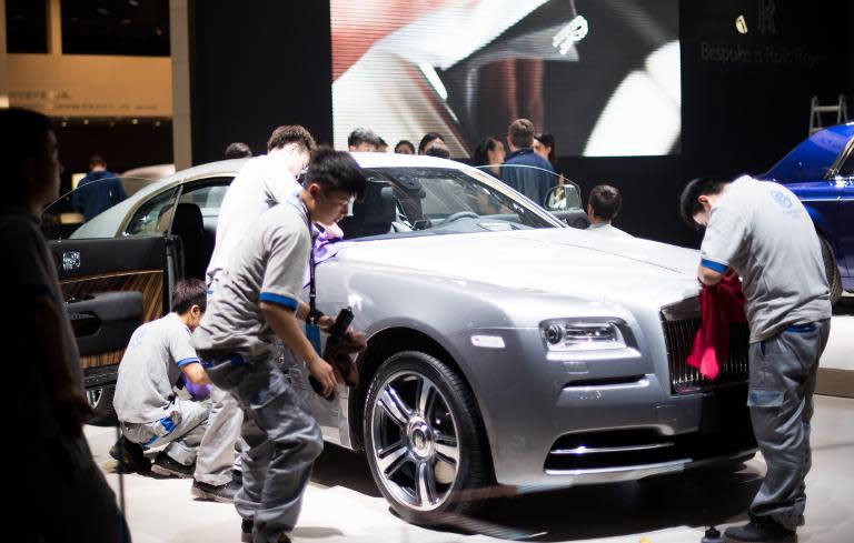 Workers clean a Rolls-Royce on April 19, 2015 ahead of the 16th Shanghai International Automobile Industry Exhibition