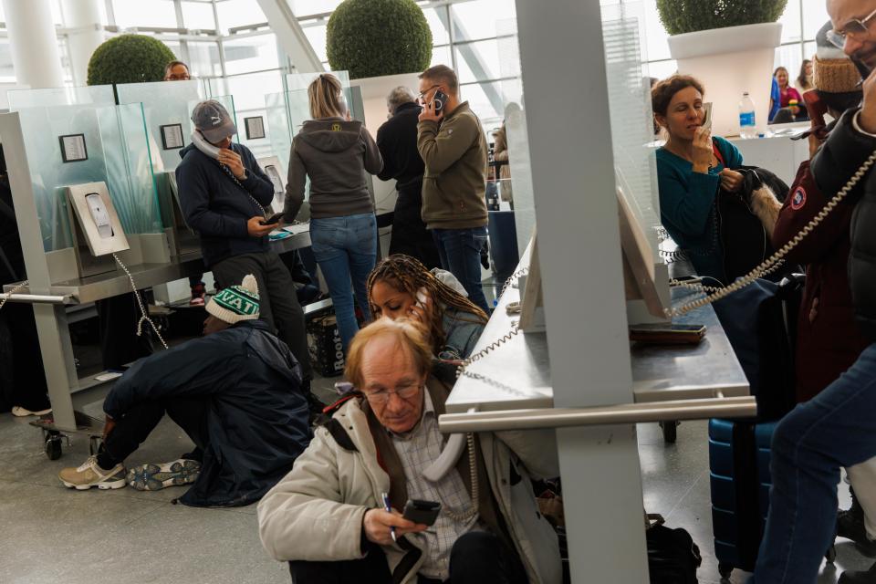 Travellers wait on hold as they try and speak with their respective airlines at Toronto Pearson International Airport, as a major winter storm disrupts flights in and out of the airport, in Toronto, Saturday, Dec. 24, 2022 (AP)