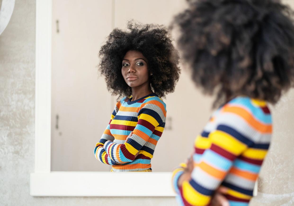 Woman looking at her reflection in the mirror