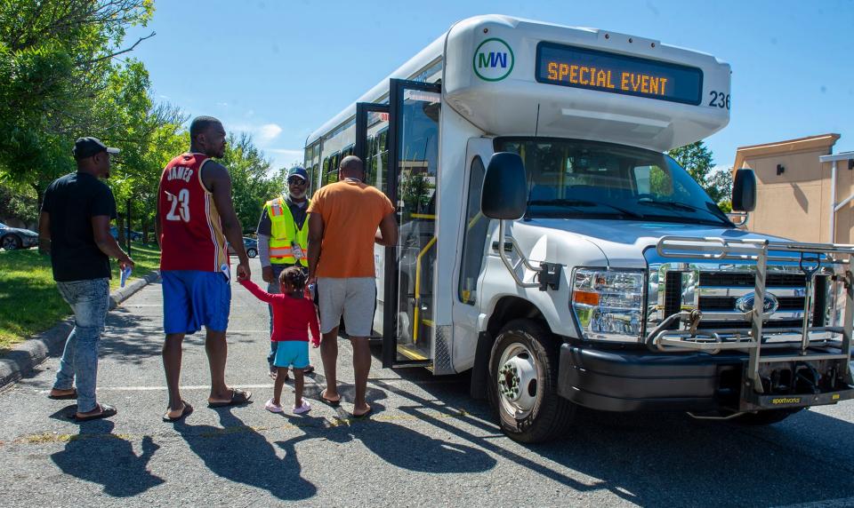 Giovanni Fleurancois, general manager for National Express, the Metrowest Regional Transit Authority's transportation company, instructs Haitian asylum seekers living in Framingham how to use the MWRTA bus system, Aug. 31, 2023. Families were given free "catch cards" good for three months from the MWRTA.