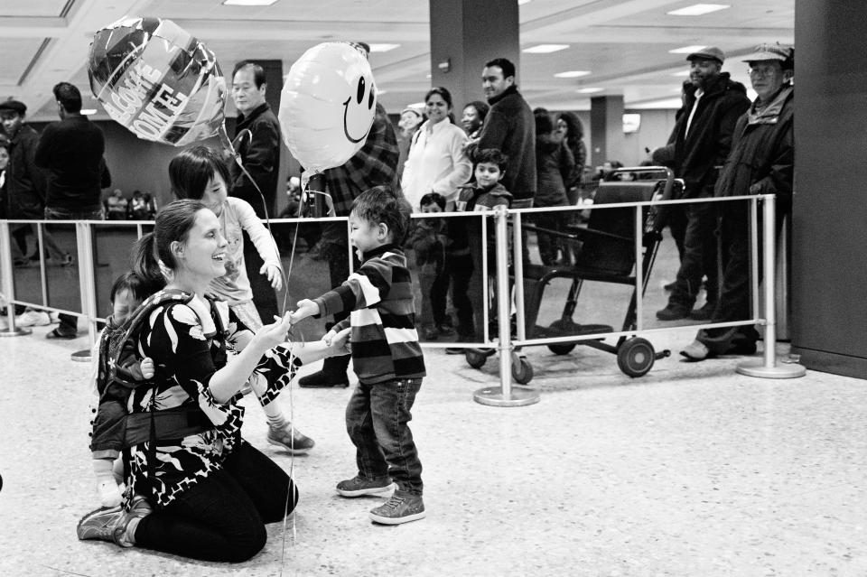 "Emily is greeted at the airport by her two older sons after bringing home Noa from South Korea." -- Sandra Eminger