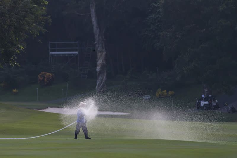 A course worker sprays water on the fairway at the Hong Kong Golf Club, in Hong Kong