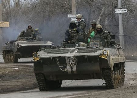 Members of the Ukrainian armed forces ride on armoured personnel carriers near Artemivsk, eastern Ukraine, March 3, 2015. REUTERS/Gleb Garanich