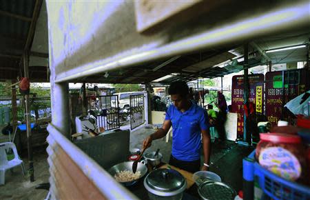 A Rohingya man cooks at his family's rented house in Cheras Baru, Kuala Lumpur March 2, 2014. REUTERS/Samsul Said