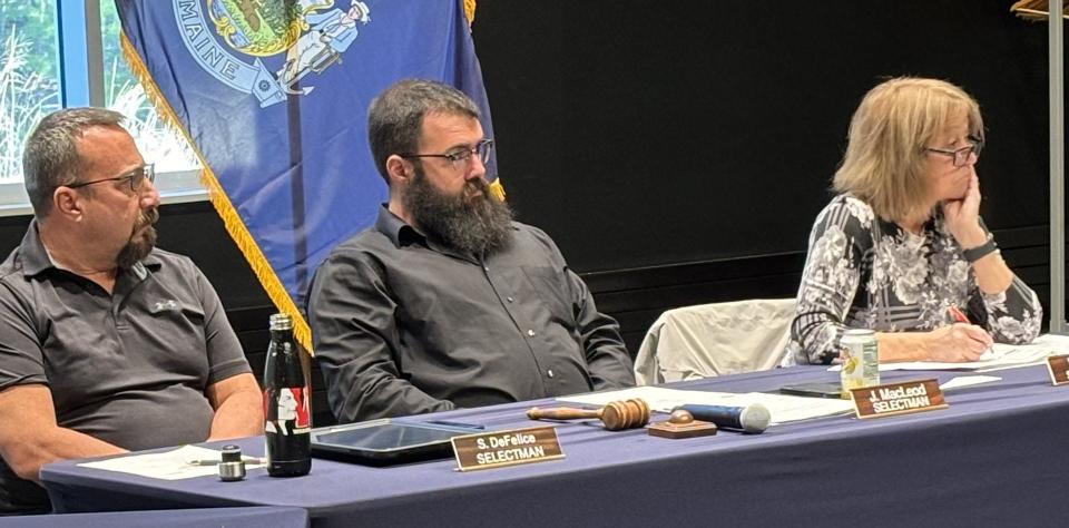 Wells Select Board member Scott DeFelice, left, Chair John MacLeod III, and Vice Chair Kathleen Chase listen as residents speak during a public hearing on a proposed moratorium on large-scale housing projects at York County Community College on April 16, 2024.