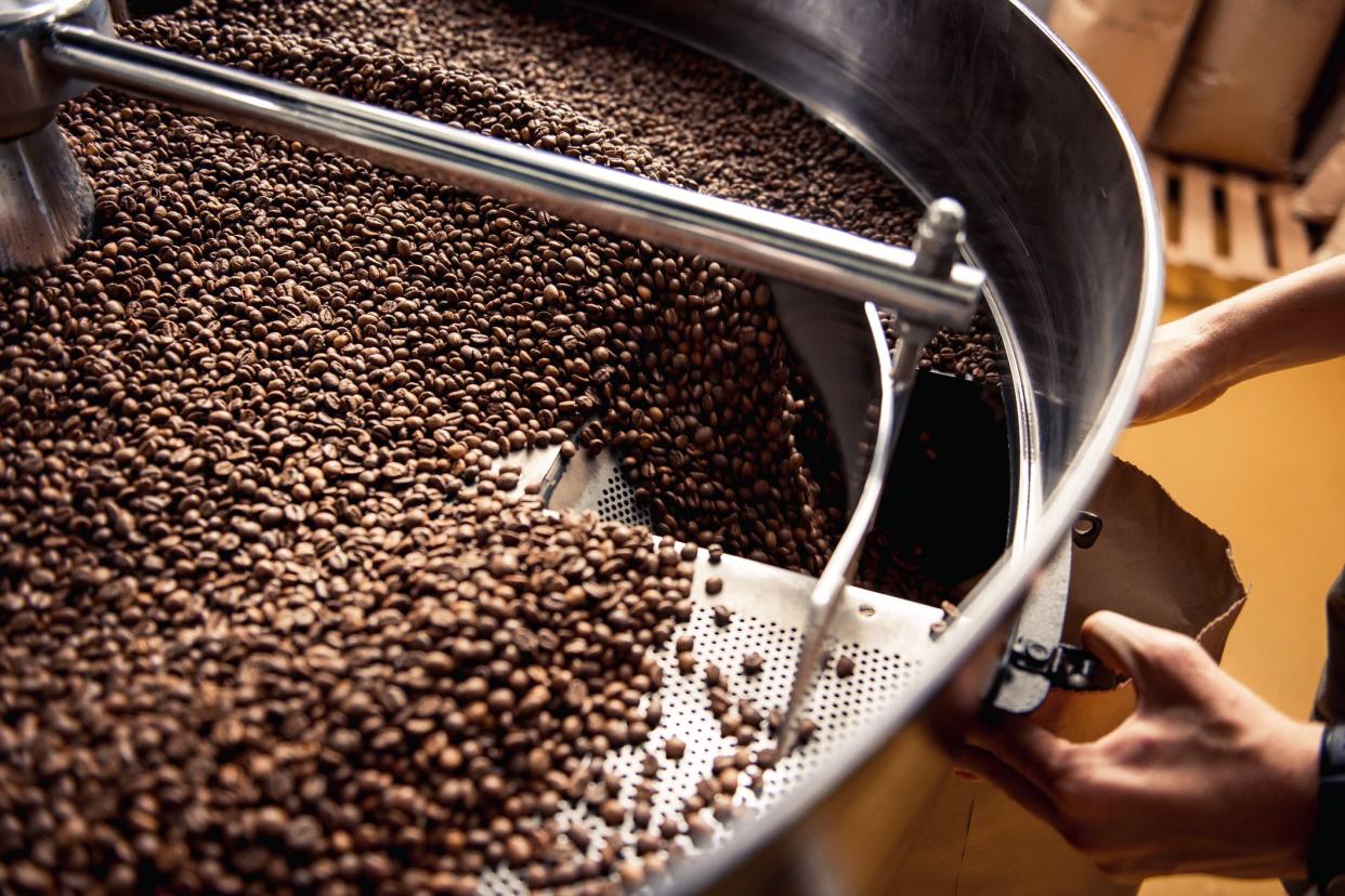 hands holding bag for falling roasted coffee grains