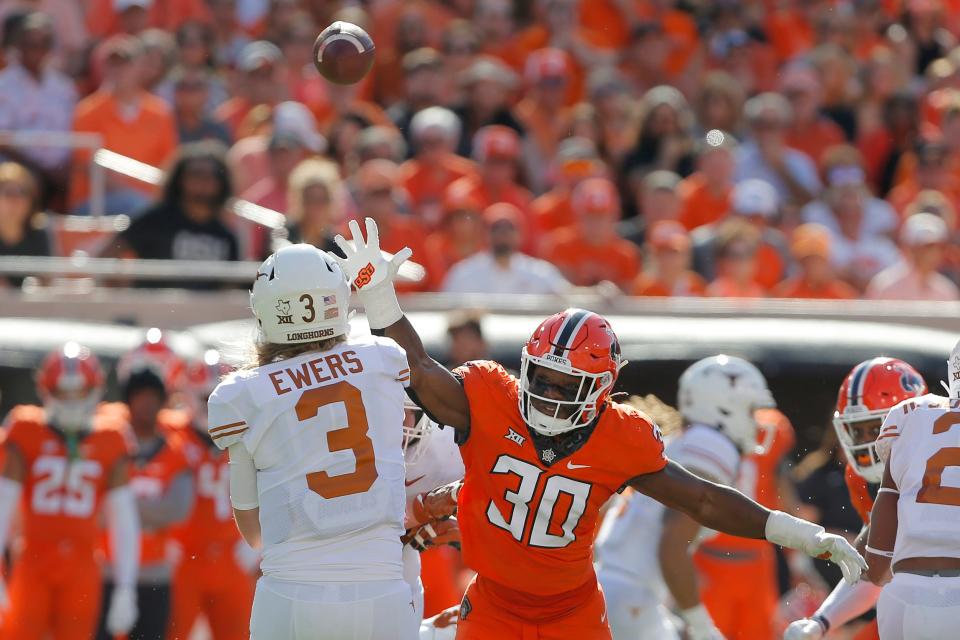 Oklahoma State Cowboys defensive end Collin Oliver (30) puts pressure on Texas Longhorns quarterback Quinn Ewers (3) during a college football game between the Oklahoma State Cowboys (OSU) and the University of Texas Longhorns at Boone Pickens Stadium in Stillwater, Okla., Saturday, Oct. 22, 2022. Oklahoma State won 41-34.