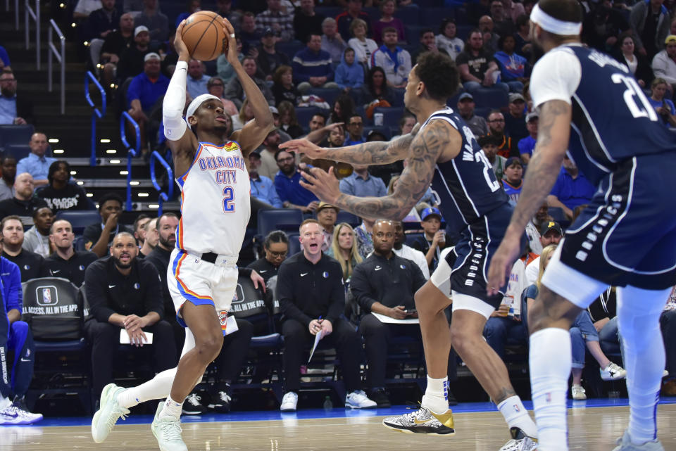 Oklahoma City Thunder guard Shai Gilgeous-Alexander, left, drives past Dallas Mavericks forward P.J. Washington , right, in the second half of an NBA basketball game, Thursday, March 14, 2024, in Oklahoma City. (AP Photo/Kyle Phillips)